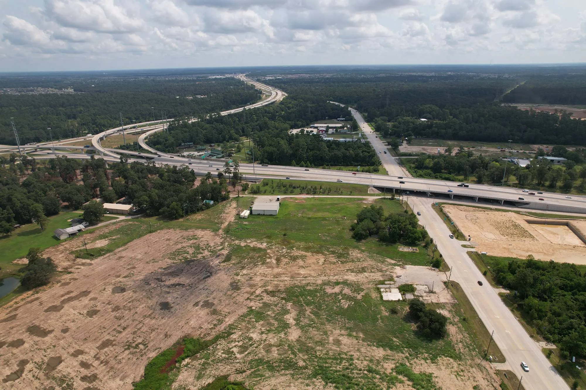 Drone aerial of a development tract beside a freeway interchange